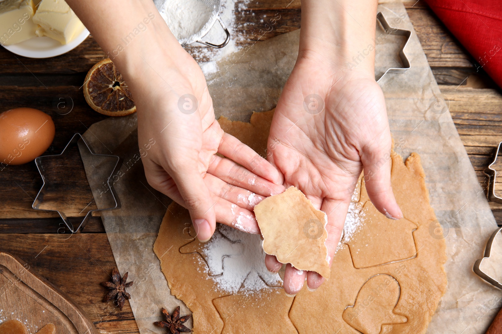 Photo of Woman making Christmas cookies at wooden table, top view