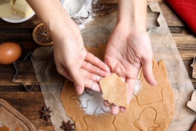 Photo of Woman making Christmas cookies at wooden table, top view