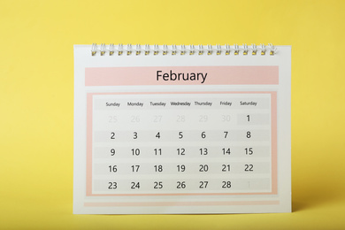 Photo of Paper calendar on yellow background. Planning concept