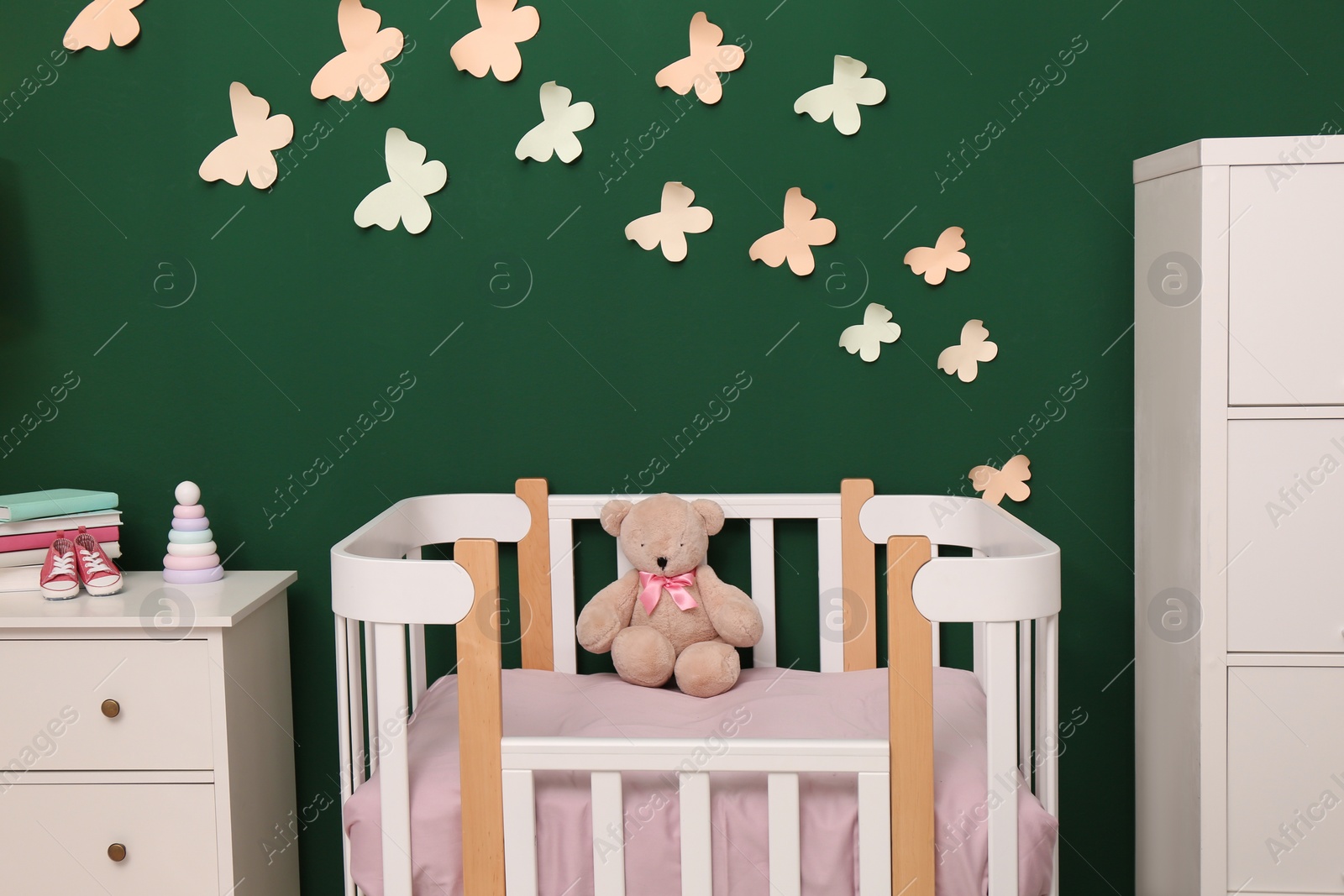 Photo of Beautiful baby room interior with stylish furniture and comfortable crib