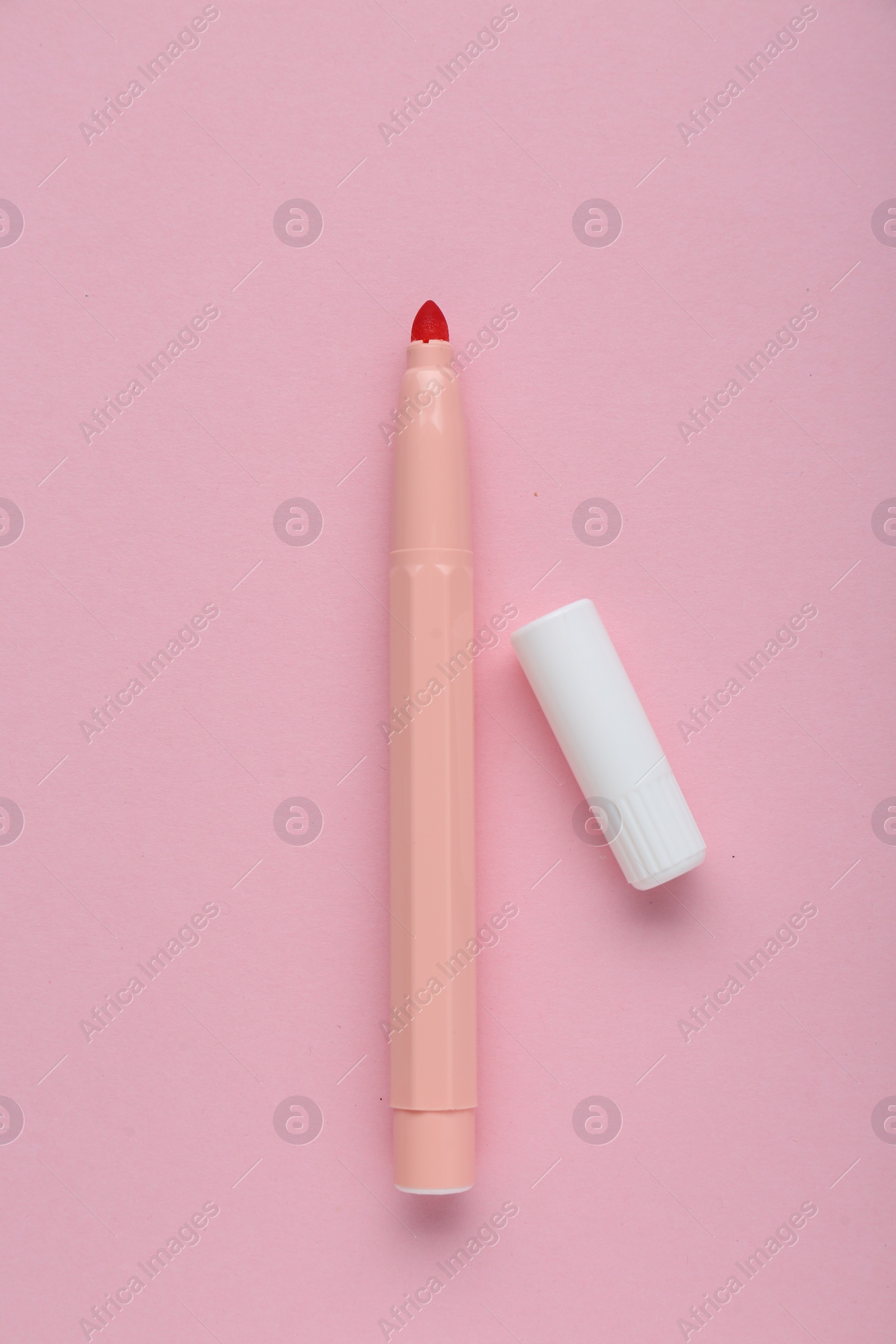 Photo of Bright marker and cap on light pink background, flat lay