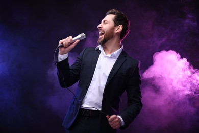 Photo of Emotional man with microphone singing in neon lights