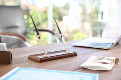 Photo of Office pen holder, sealed document and vintage stamp on desk in notary's office