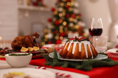 Festive dinner with delicious cake served on table indoors, space for text. Christmas Eve celebration