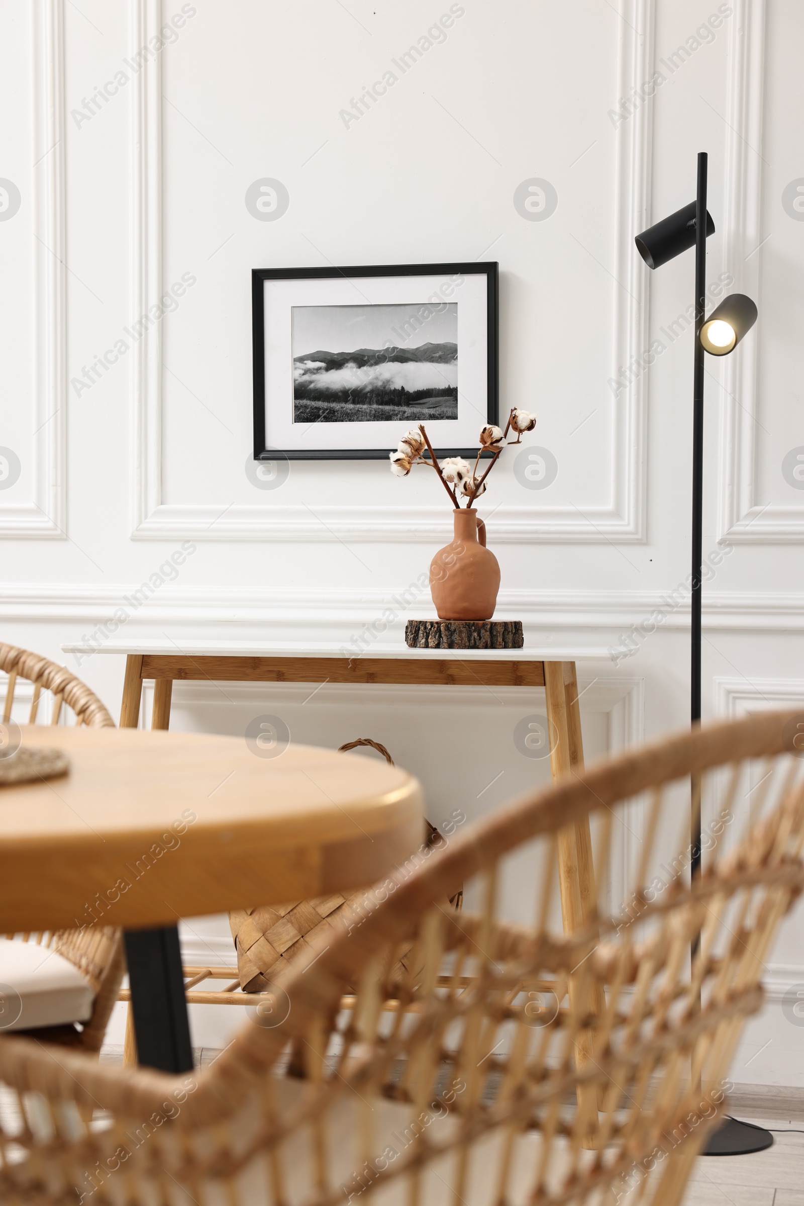 Photo of Tasty croissants on table and wicker chairs in dining room. Interior design