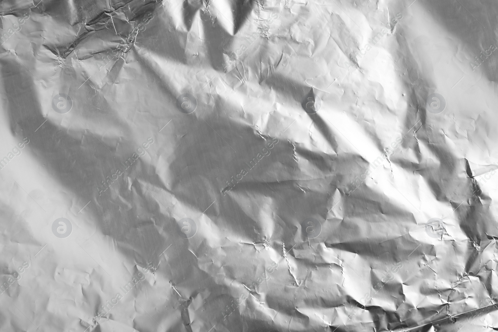 Photo of Crumpled silver foil as background, closeup view