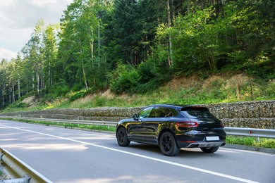 Photo of Picturesque view of asphalt road with modern black car