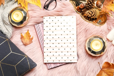 Photo of Flat lay composition with books, candles and autumn leaves on fuzzy rug