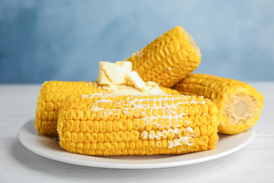 Delicious boiled corn with butter on white wooden table