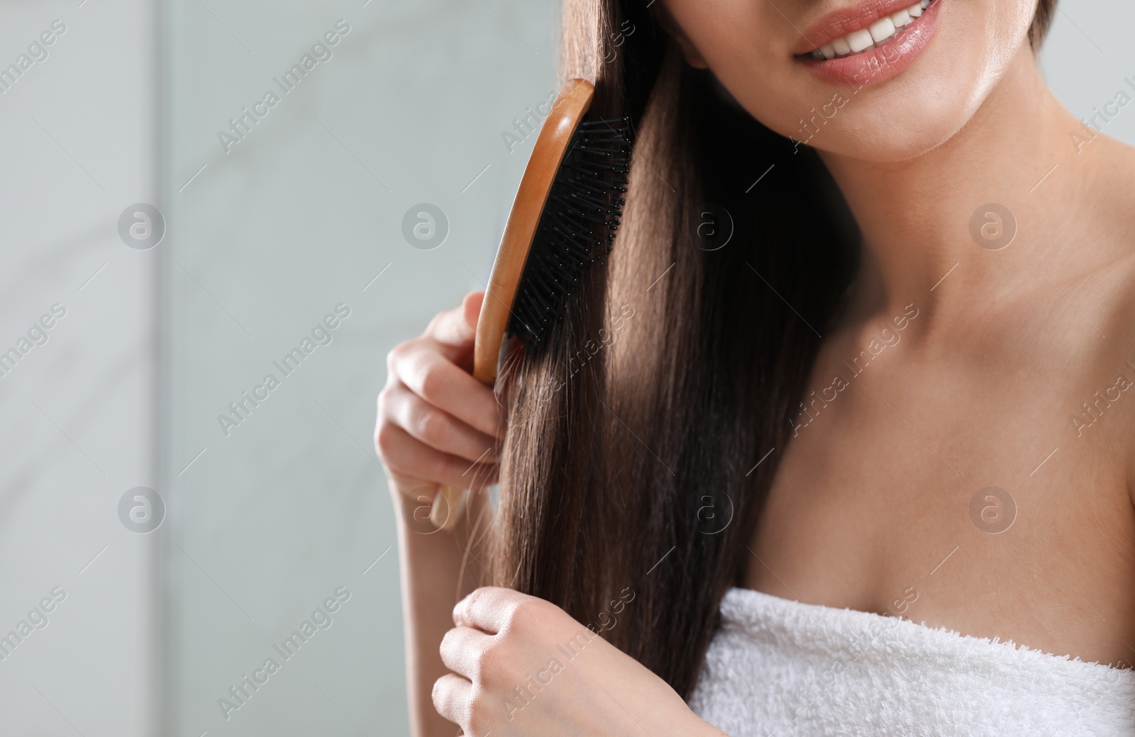 Photo of Young woman with hair brush in bathroom, closeup view