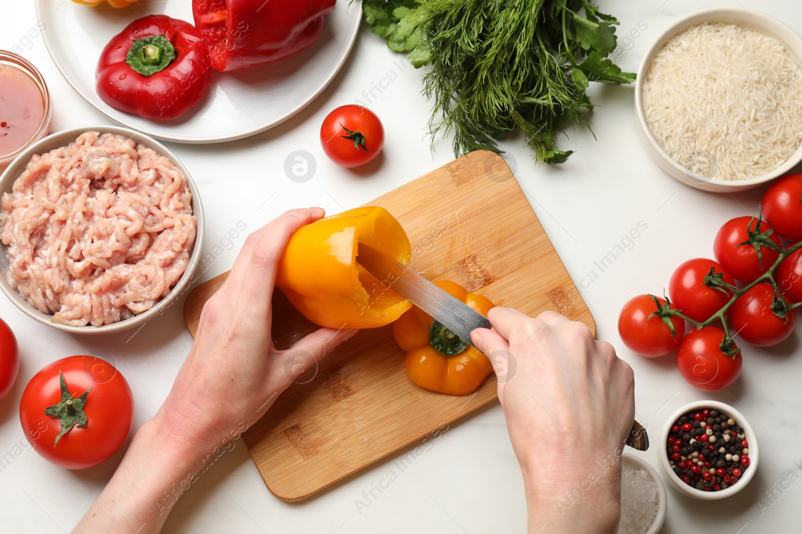 Photo of Woman making stuffed peppers with ground meat at white table, top view