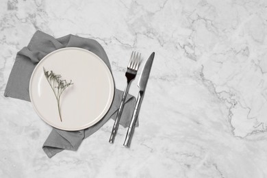 Stylish setting with elegant cutlery on white marble table, top view. Space for text