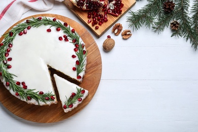 Photo of Flat lay composition with traditional Christmas cake on white wooden table. Space for text