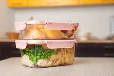 Photo of Boxes with prepared meals on table against blurred background