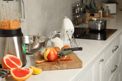 Photo of Modern mixer, blender and different ingredients on white marble countertop in kitchen, space for text