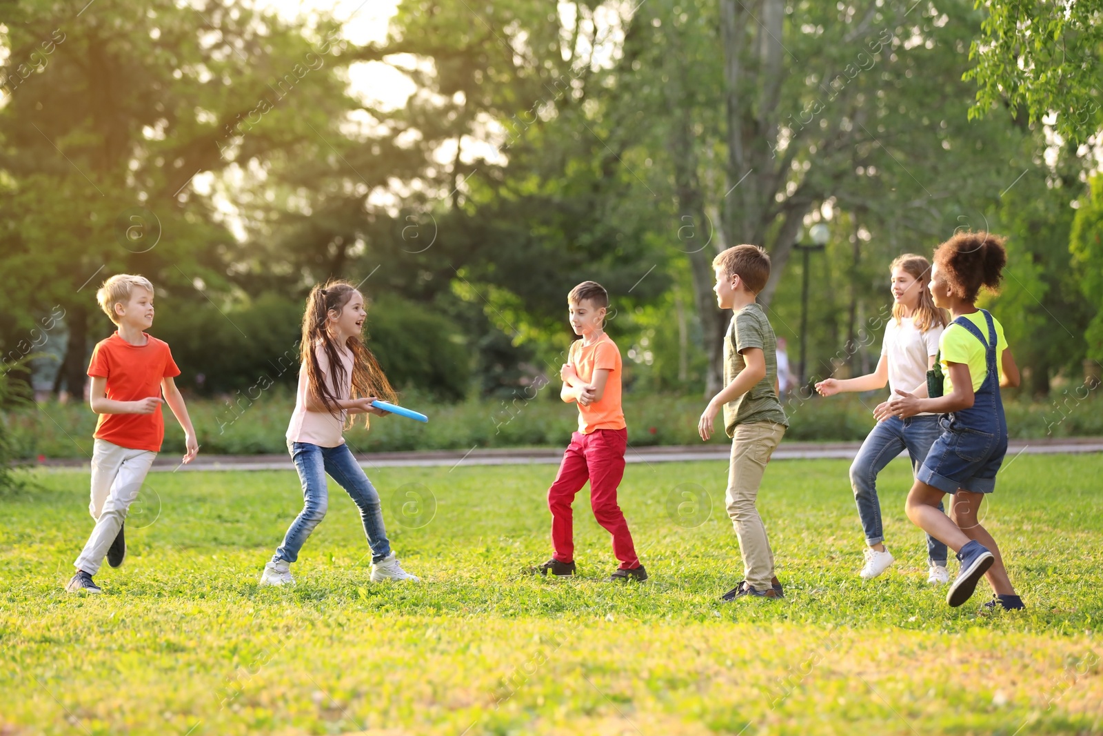 Photo of Cute little children playing with frisbee outdoors on sunny day