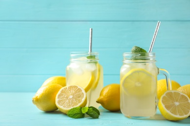 Photo of Natural lemonade with mint on light blue wooden table. Summer refreshing drink