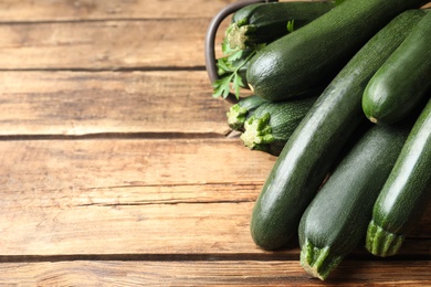 Green zucchinis on wooden table, closeup. Space for text