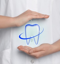 Image of Dentist demonstrating virtual image of healthy tooth on light blue background, closeup