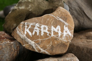 Photo of Closeup view of stone with word Karma