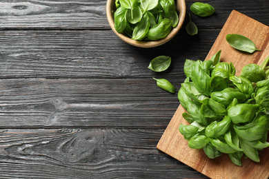 Photo of Fresh green basil on black wooden table, flat lay. Space for text