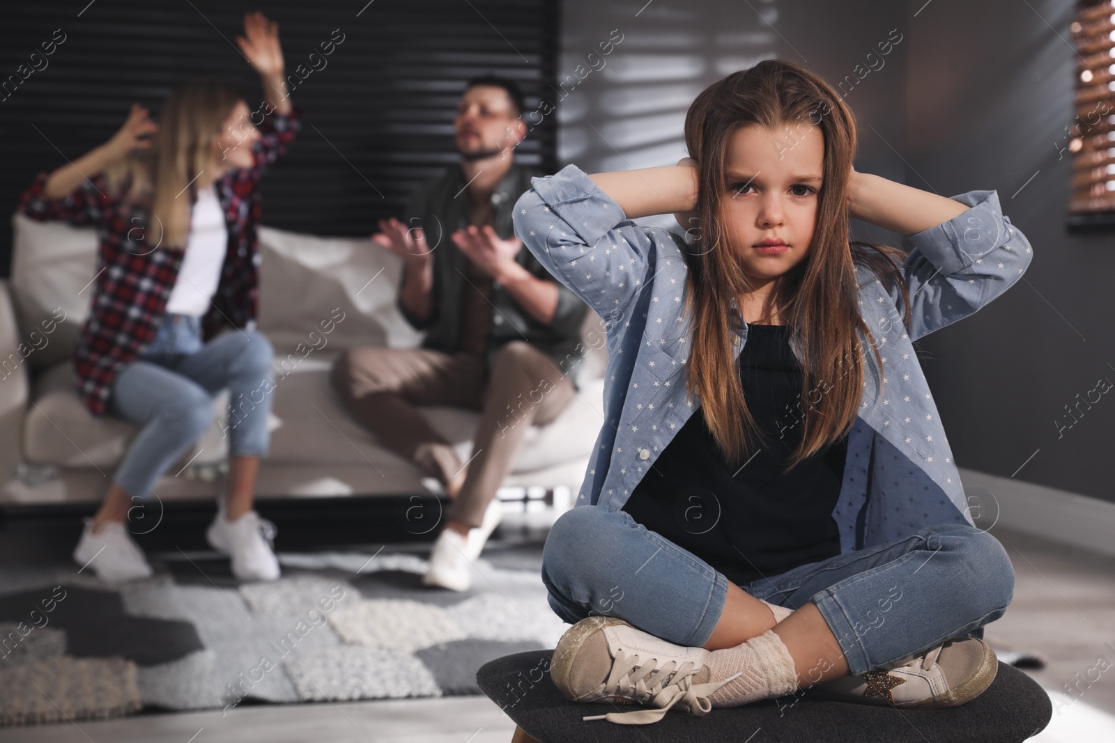 Photo of Couple fighting at home, focus on their unhappy little daughter. Domestic violence