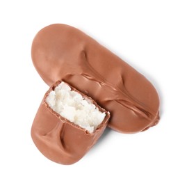 Photo of Delicious milk chocolate candy bars with coconut filling on white background, top view