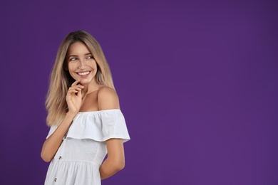 Photo of Young woman wearing stylish white dress on purple background. Space for text