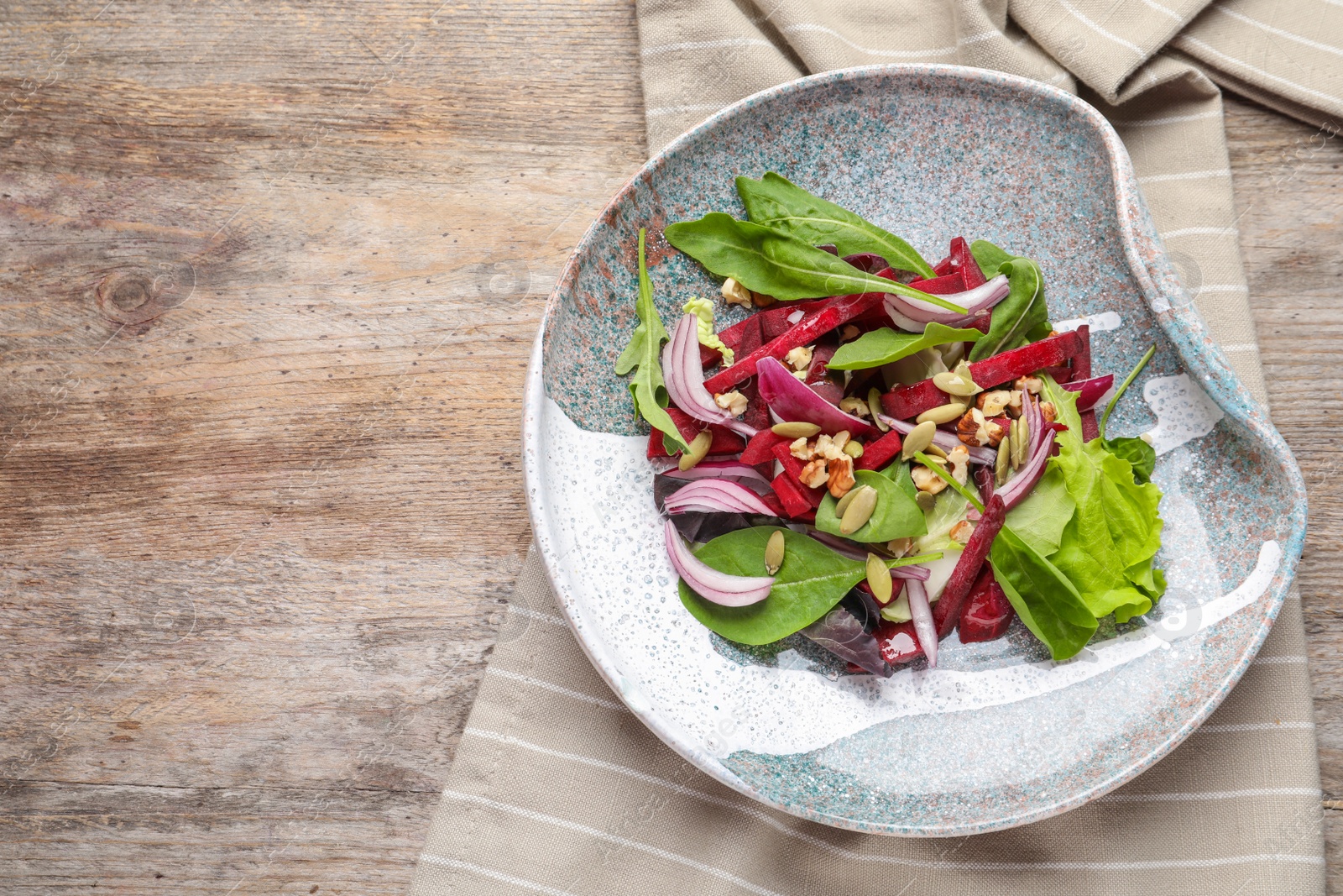 Photo of Plate with delicious beet salad on wooden background, top view