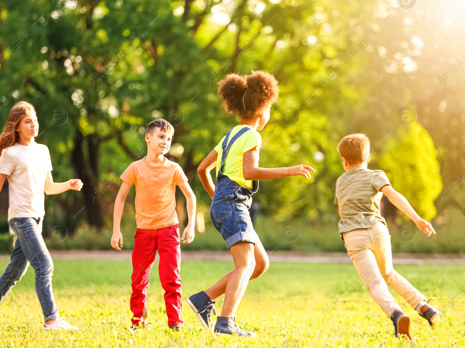 Image of School holidays. Group of happy children playing outdoors 