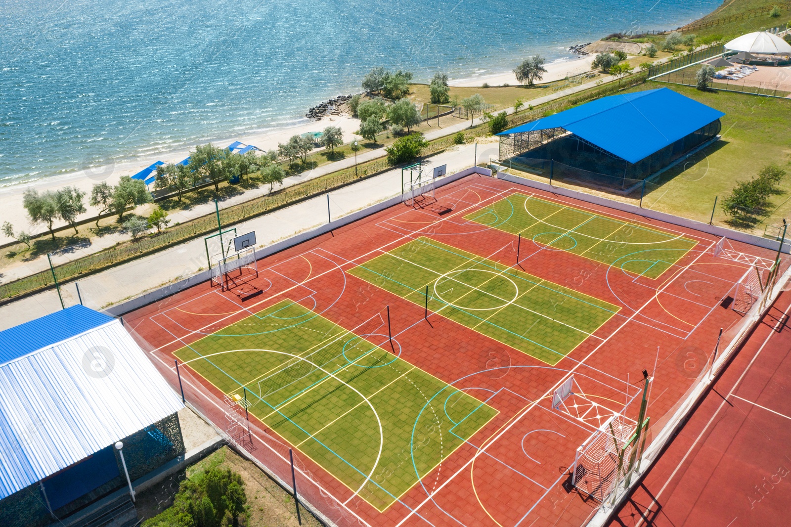 Image of Outdoor sports complex near sea on sunny day, aerial view