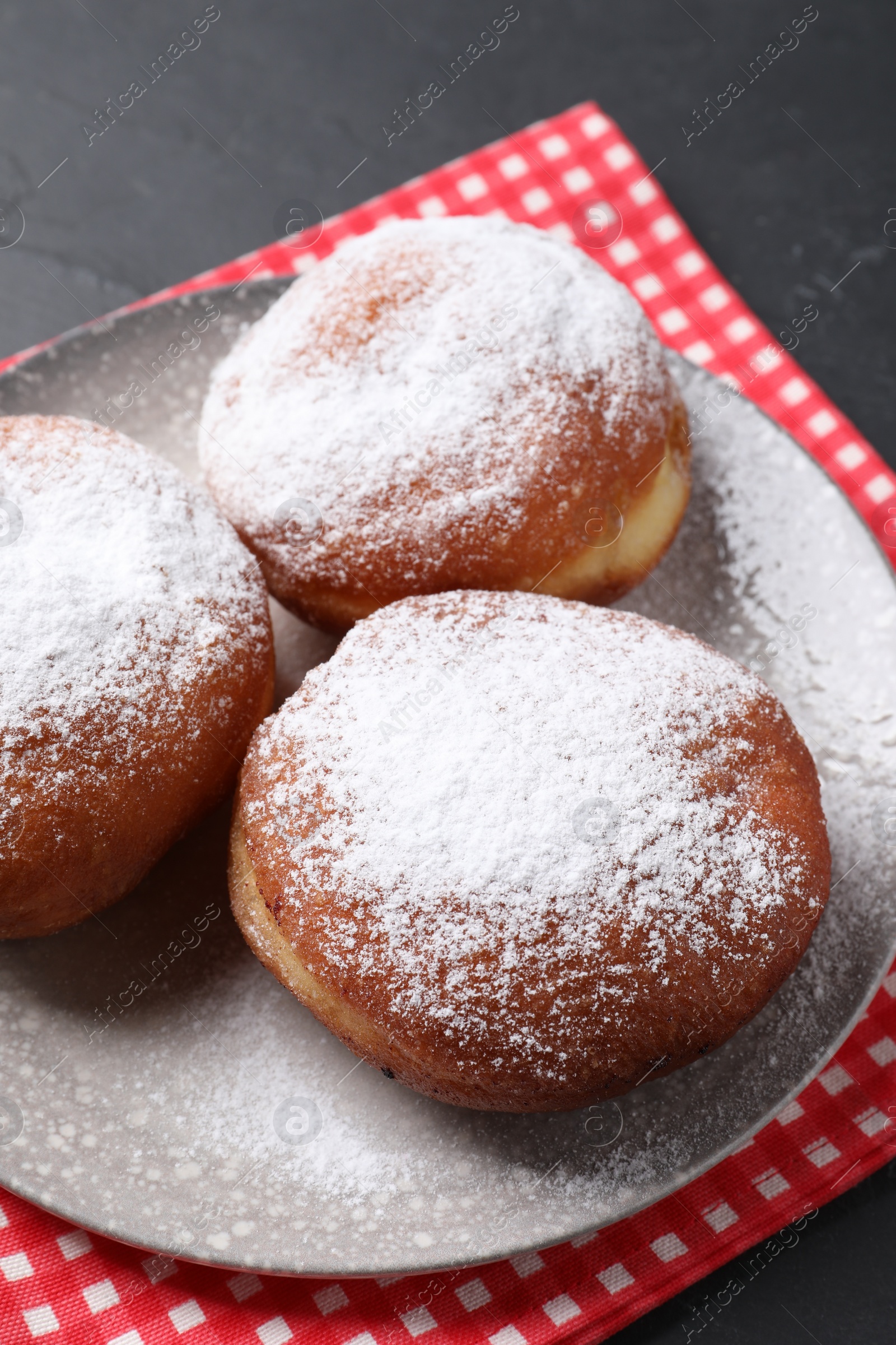 Photo of Delicious sweet buns with powdered sugar on table, closeup