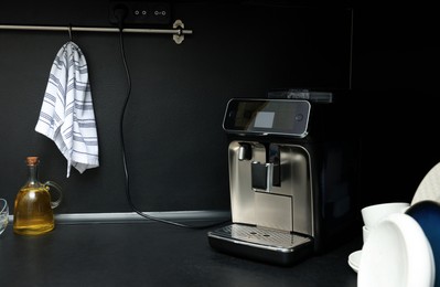 Photo of Coffee machine and kitchen utensils on black countertop