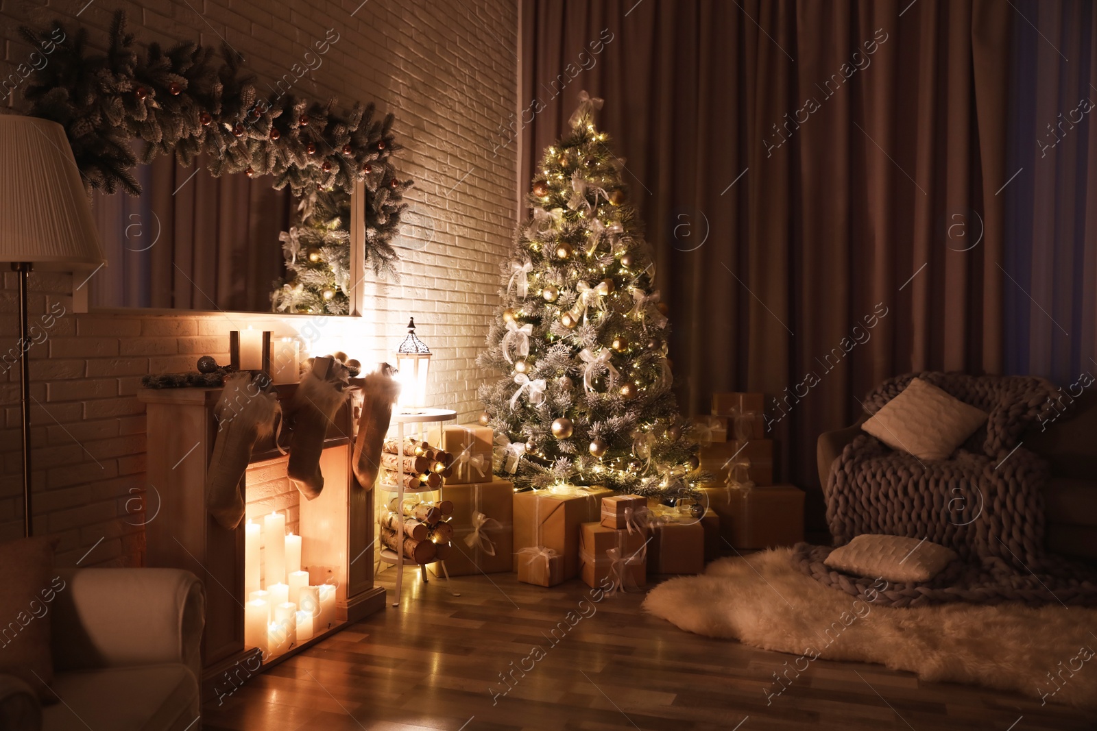 Photo of Stylish interior with beautiful Christmas tree and artificial fireplace at night