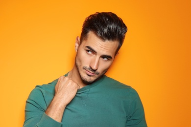 Photo of Young man with trendy hairstyle posing on color background