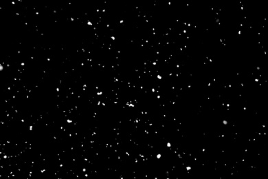 Photo of White snow falling down on black background