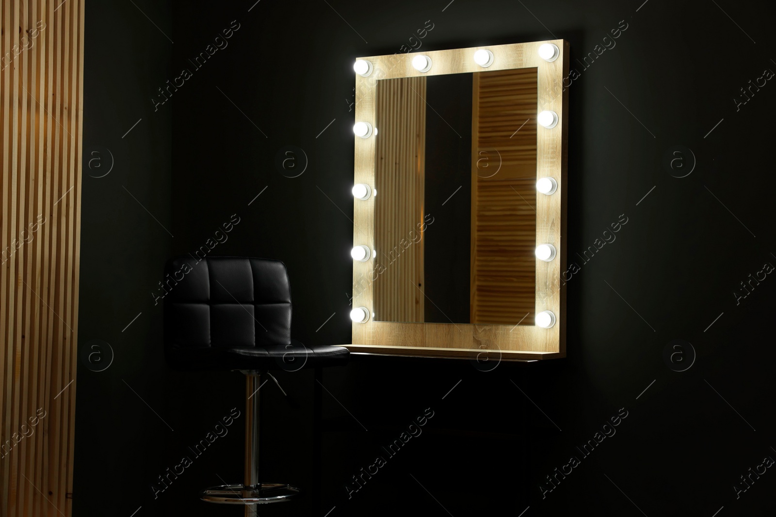 Photo of Beautiful mirror with light bulbs and chair in makeup room