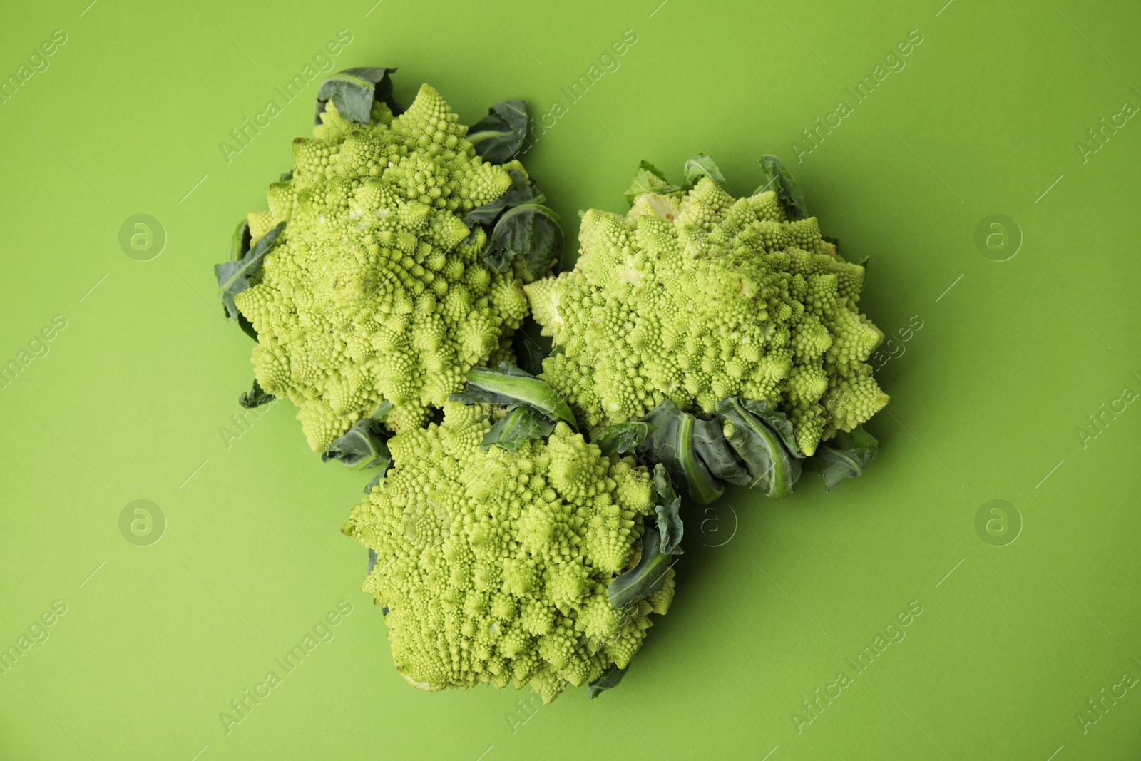 Photo of Fresh Romanesco broccoli on green background, flat lay