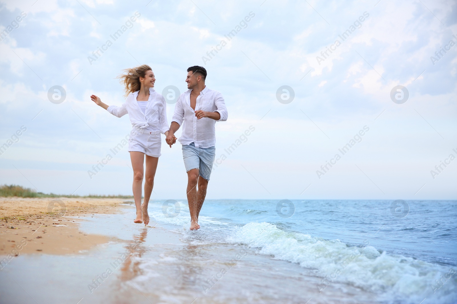 Photo of Happy couple running on beach, space for text. Romantic walk