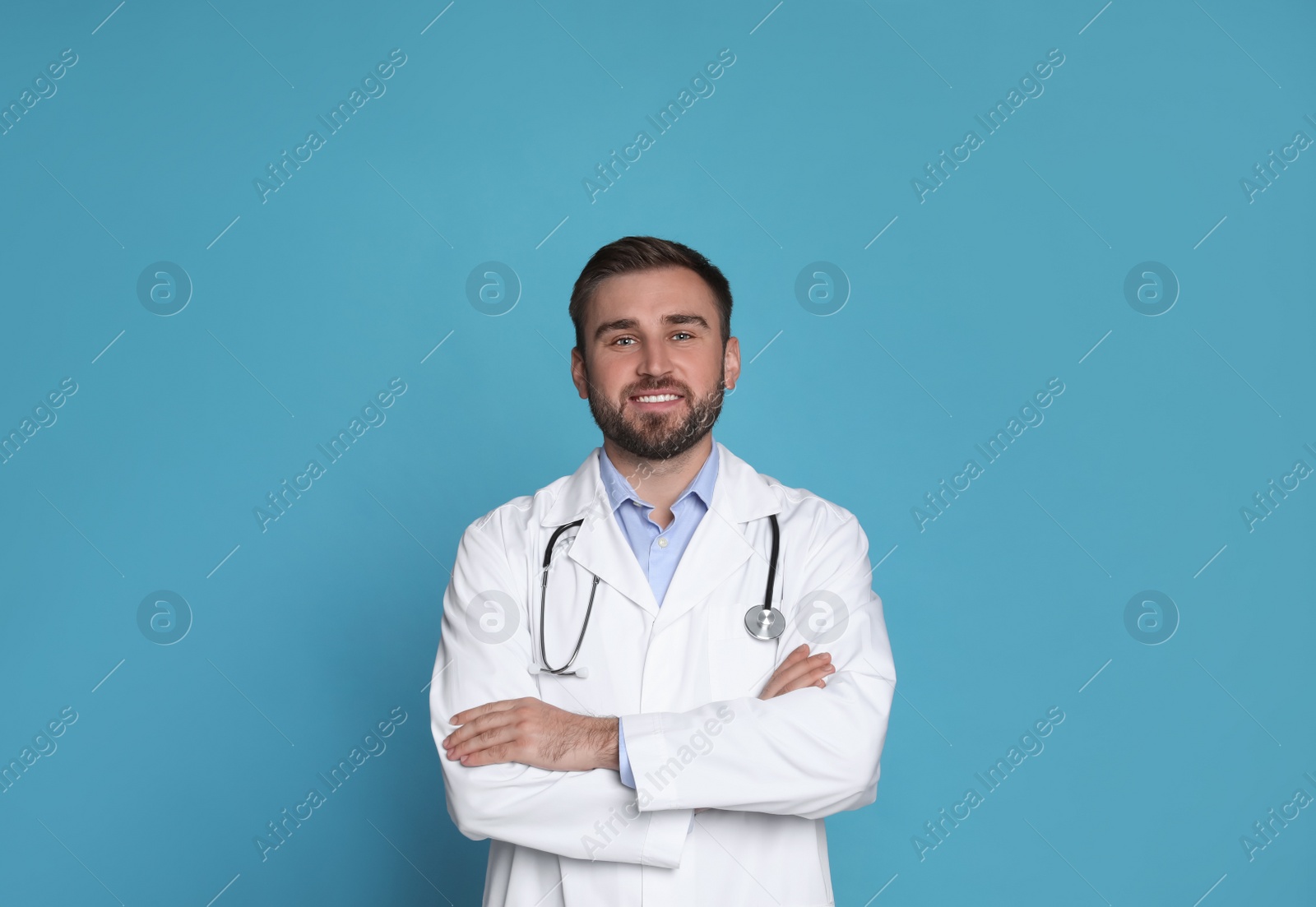 Photo of Portrait of young doctor on light blue background
