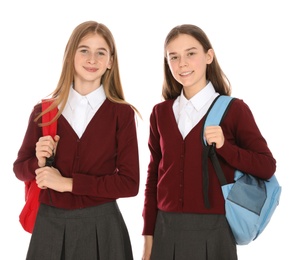 Photo of Portrait of teenage girls in school uniform with backpacks on white background