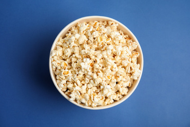 Tasty pop corn on blue background, top view