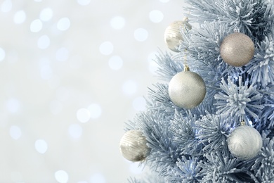 Beautiful decorated Christmas tree against blurred lights, closeup with space for text. Bokeh effect