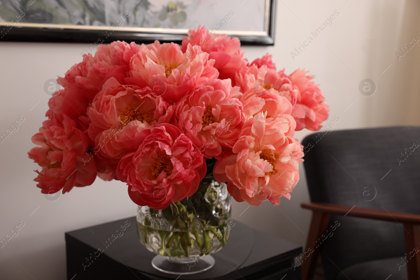 Photo of Beautiful pink peonies in vase on nightstand indoors