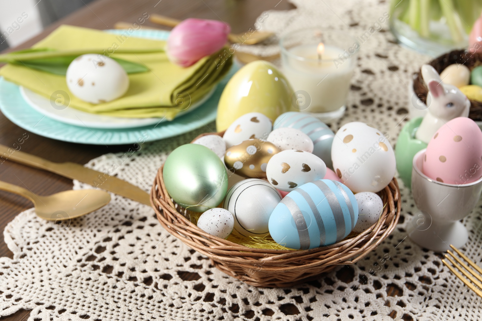 Photo of Festive table setting with painted eggs. Easter celebration