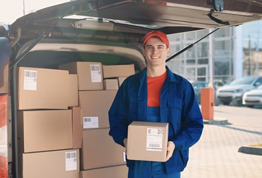 Courier with parcel near delivery van outdoors, space for text