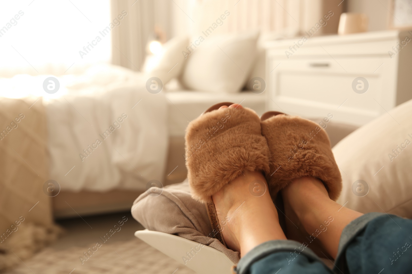 Photo of Woman wearing soft comfortable slippers at home, closeup. Space for text