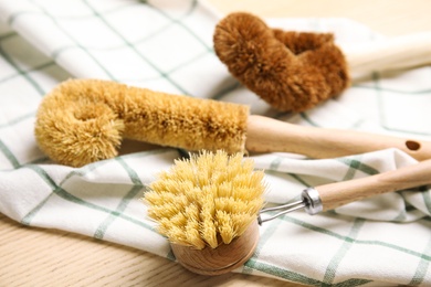 Cleaning brushes for dish washing on wooden table, closeup