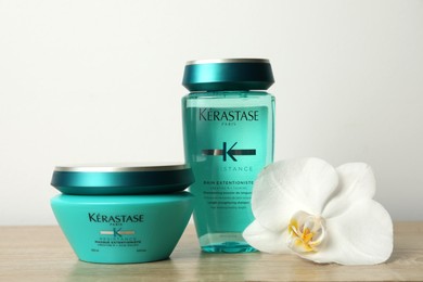 MYKOLAIV, UKRAINE - SEPTEMBER 07, 2021: Kerastase hair care cosmetic products and beautiful orchid flower on wooden table