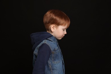Photo of Little boy on black background. Children's bullying